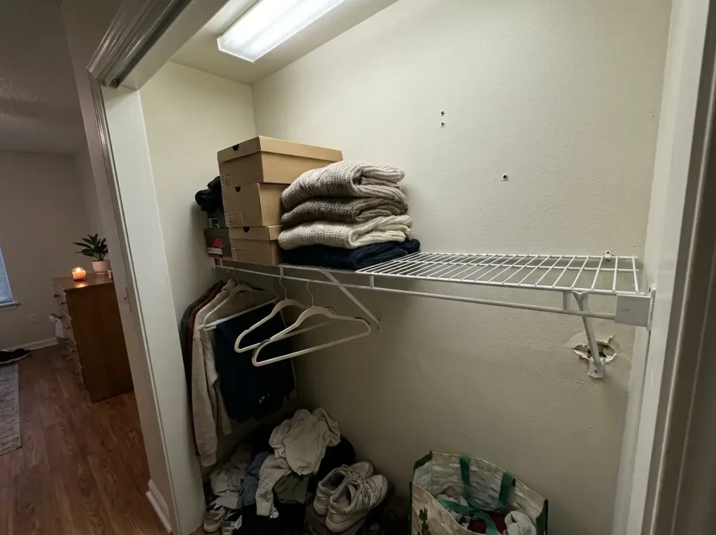 Sagging wire closet shelf overloaded with heavy sweaters and shoe boxes