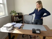 11 Desk Organization Ideas That Actually Last Woman beginning to organize a cluttered home office desk with bins and dividers nearby