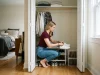 Best Shoe Organizers for Every Space and Budget Woman choosing shoe organizers for a small reach-in closet, sneakers on a tiered rack