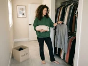 Why the One-In-One-Out Rule Stops Working by Month 3 Woman holding two items deciding which to keep under the one-in-one-out decluttering rule