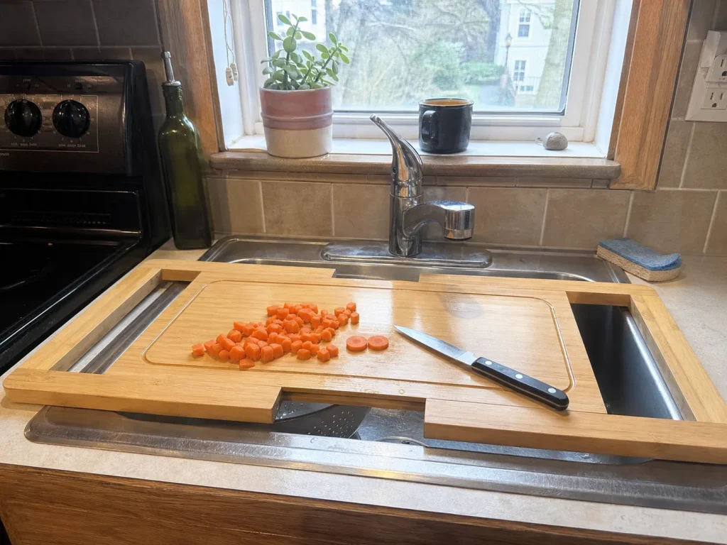Expandable wooden over-the-sink cutting board turning a kitchen sink into prep space