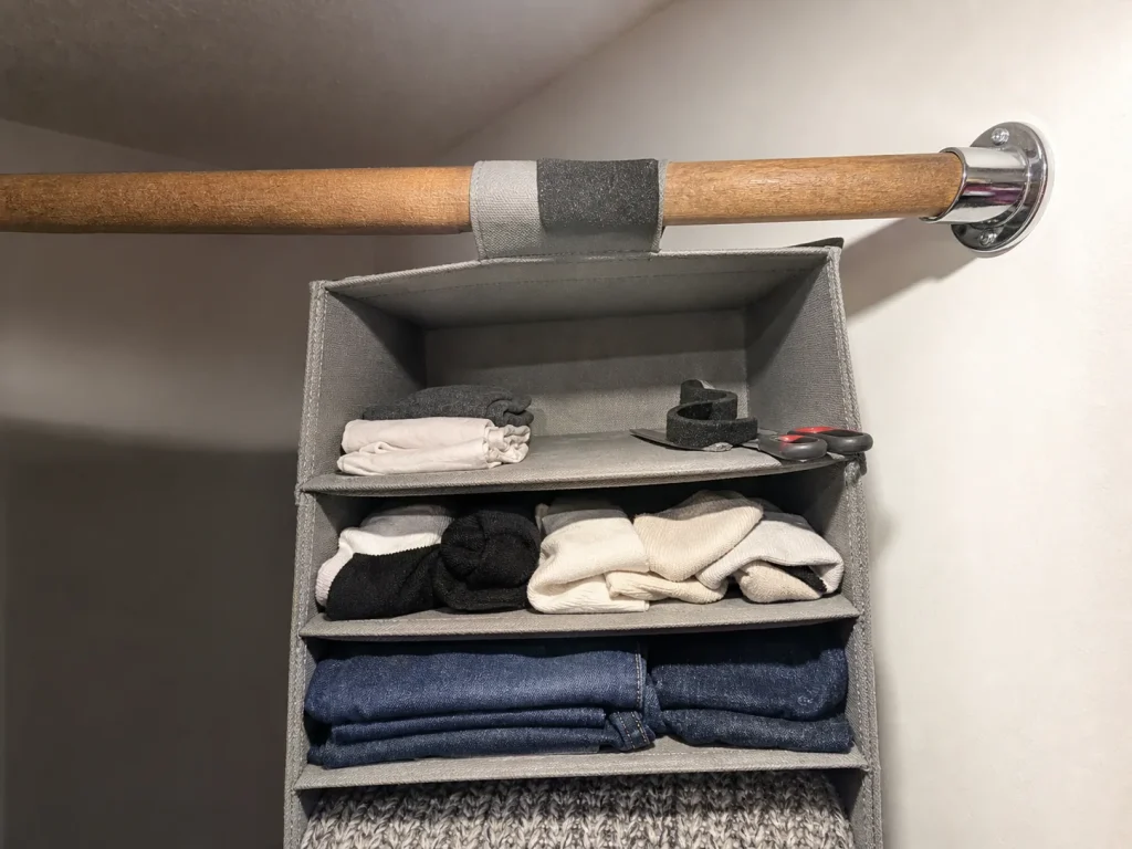Felt tape wrapped on a closet rod under a hanging organizer collar with heavy items loaded low