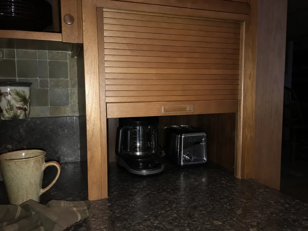 How to Organize Kitchen Counters That Stay Clear 8 Roll-up tambour appliance garage door half-open over a counter nook hiding a coffee maker