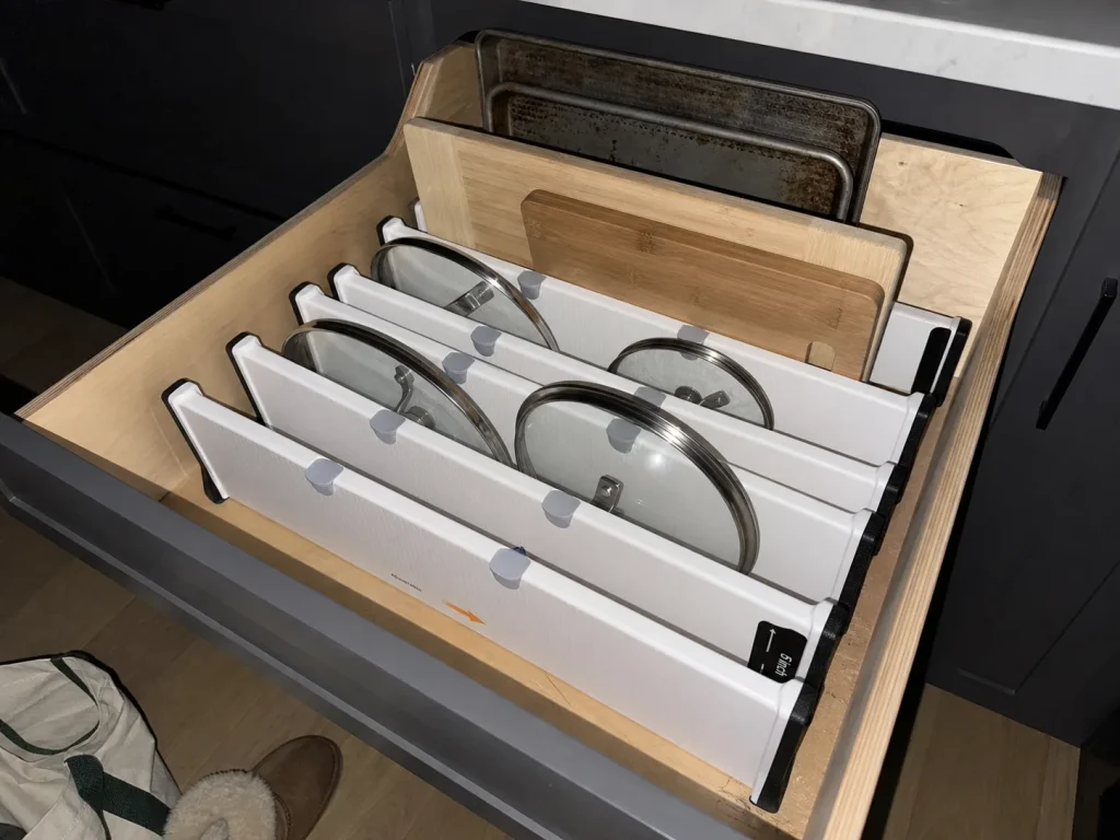 Best Kitchen Drawer Organizers That Hold Their Size 10 Pot lids and cutting boards standing upright between RAPTUROUS dividers in a deep kitchen drawer