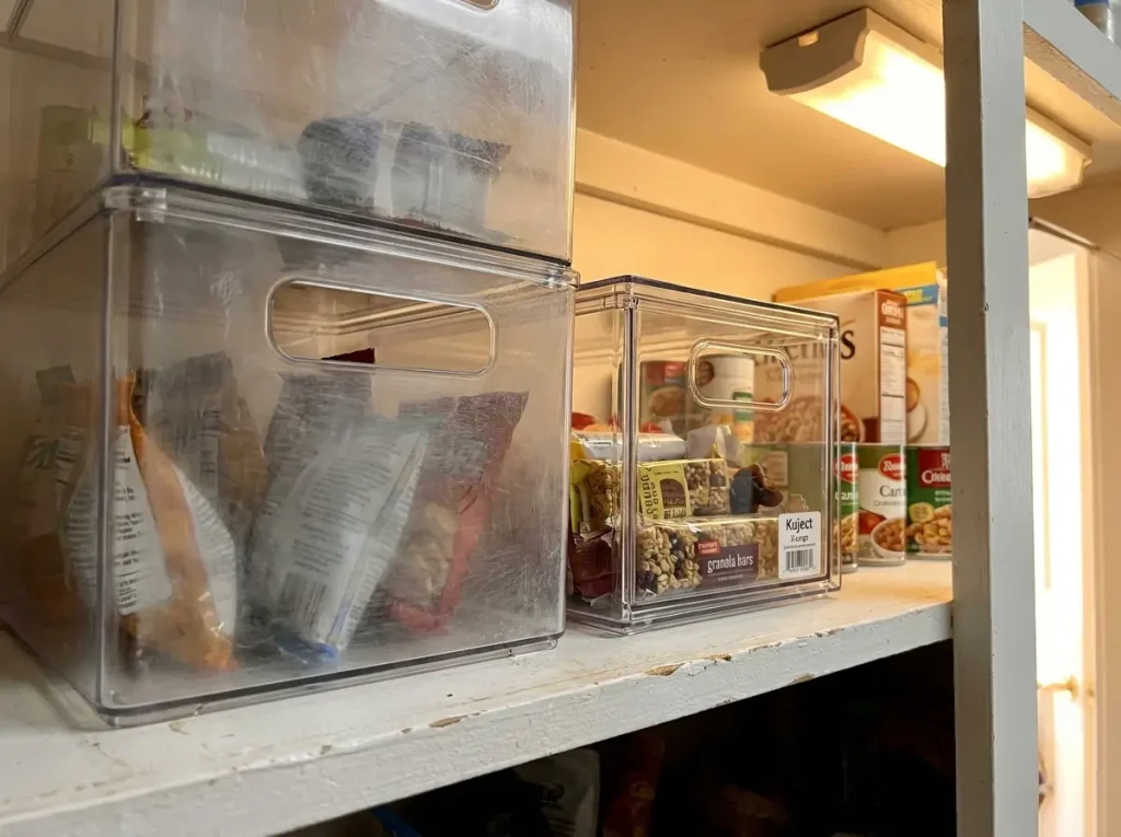 Scratched cloudy acrylic pantry bin beside a clear PET box showing where acrylic falls apart in daily use