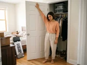 Best Over-Door Organizers That Fit Your Door Woman checking the top edge of a bedroom closet door before hanging an over-door organizer