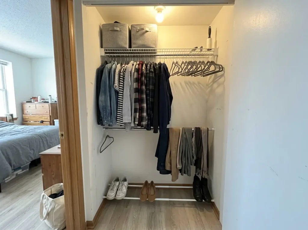 Rental closet with a double tension rod setup and an angled two-rod shoe shelf holding sneakers