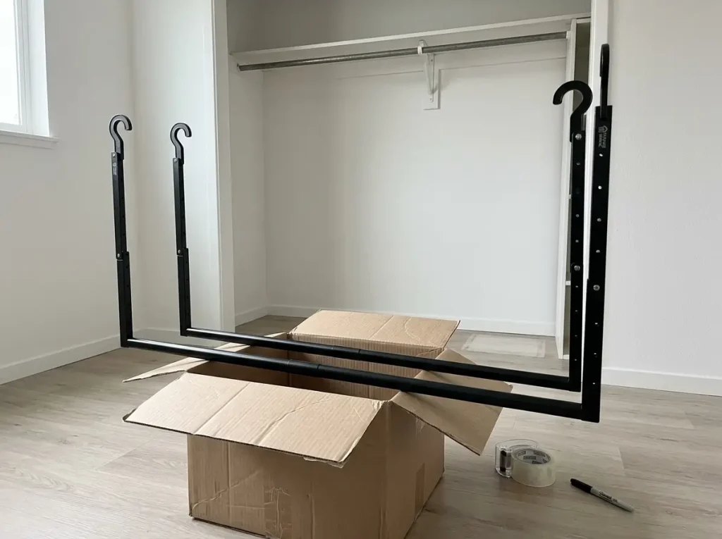 Portable closet double rod set aside during move-out next to an empty rental closet