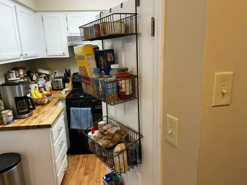 Deep over-door pantry rack on an open door swinging close to an adjacent kitchen wall