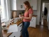 Best Spice Jar Labels That Survive Oil and Steam Woman applying round spice jar labels to glass jars on a kitchen counter in morning light