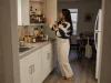 Best Spice Rack Organizers That Actually Stay Put Woman checking spice jars on a tiered cabinet rack in a small rental kitchen