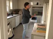 Freezer Organization Ideas That Fit Your Actual Freezer Woman filing frozen bags upright in a top-freezer during a Sunday freezer organization reset