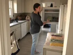 Freezer Organization Ideas That Fit Your Actual Freezer Woman filing frozen bags upright in a top-freezer during a Sunday freezer organization reset