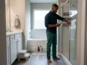 How to Organize Shower Products in a Shared Bath Man sorting shower products into two corner caddies while organizing a shared bathroom shower