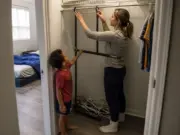 Kids Closet Organization Ideas at Your Kid’s Reach Height Mother lowering a closet rod to her son's reach height in a small rental kids closet
