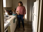 Why Your Small Kitchen With Few Drawers Stays Cluttered Woman standing in a small rental kitchen with only two drawers and utensils stacked on the counter