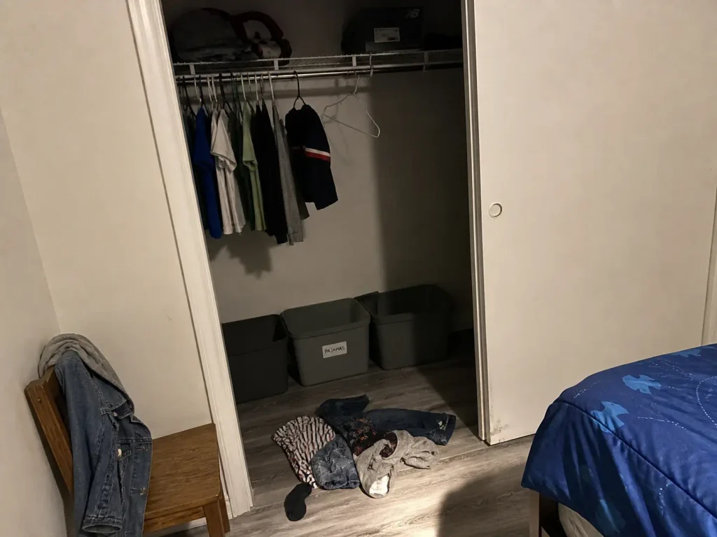 Kids clothes on the bedroom floor below a closet rod hung at adult height