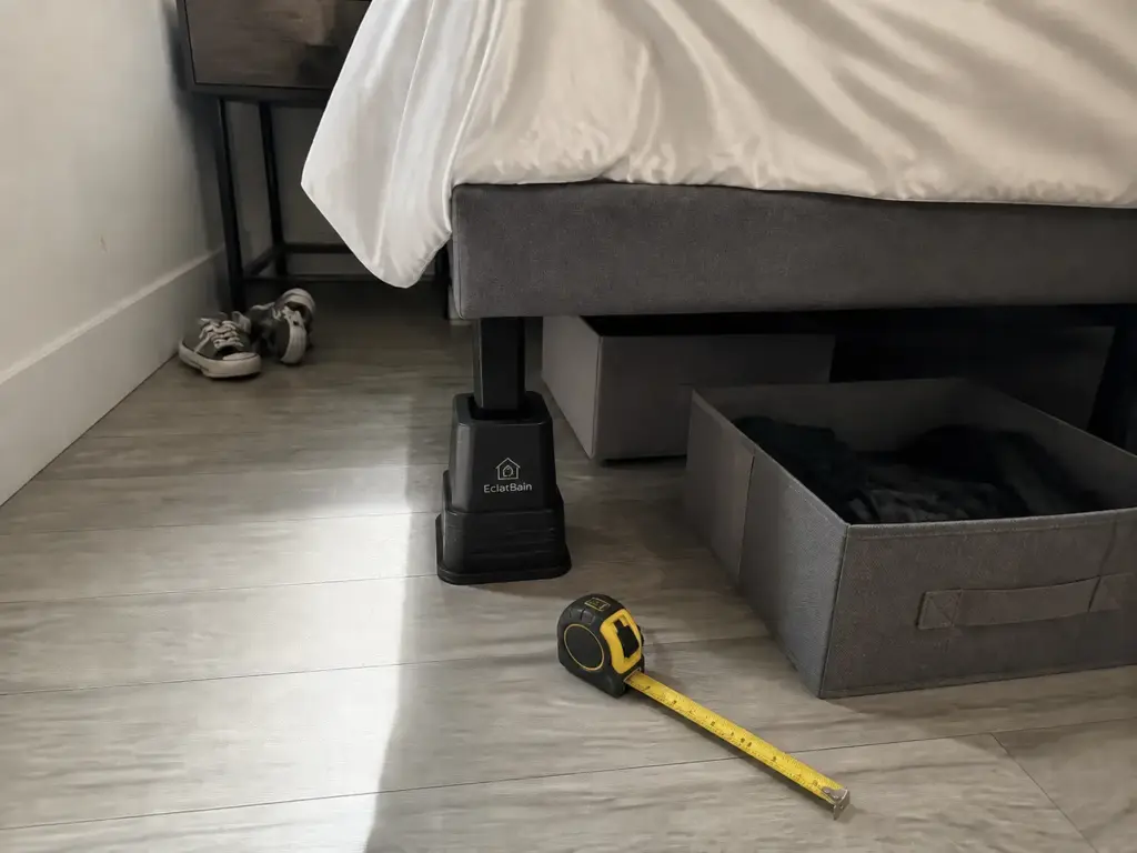 Bed risers lifting a small bedroom bed frame to open up under-bed storage clearance