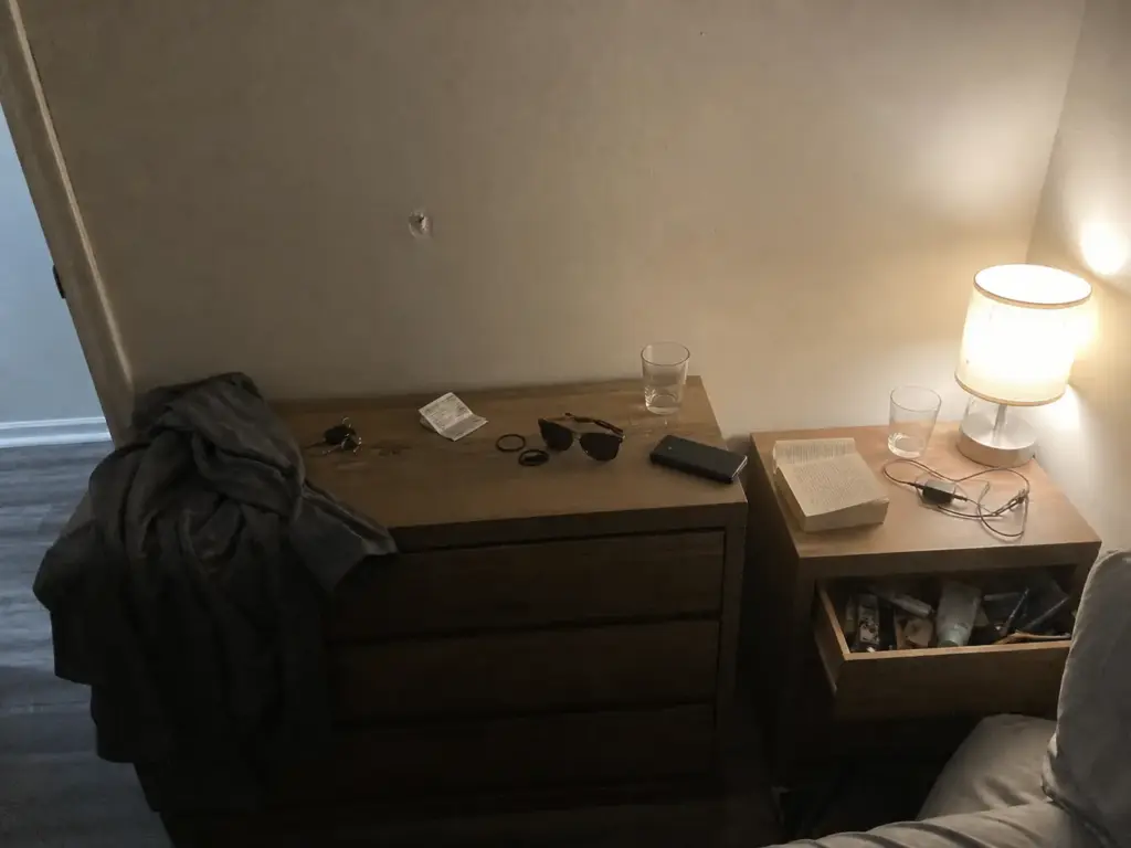 Cluttered small bedroom dresser top and nightstand a few weeks after organizing