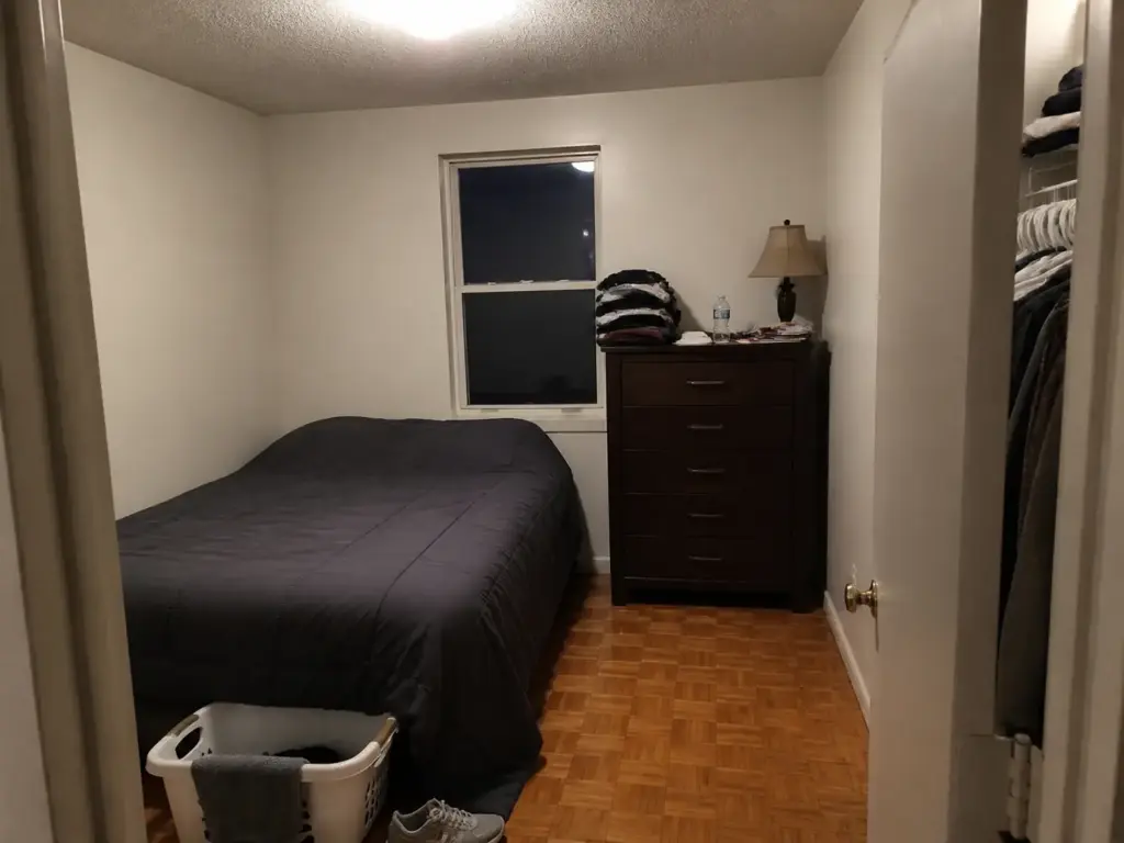 How to Make a Small Bedroom Look Bigger for Renters 1 Small rental bedroom lit by one ceiling bulb showing flat light and heavy furniture at eye level