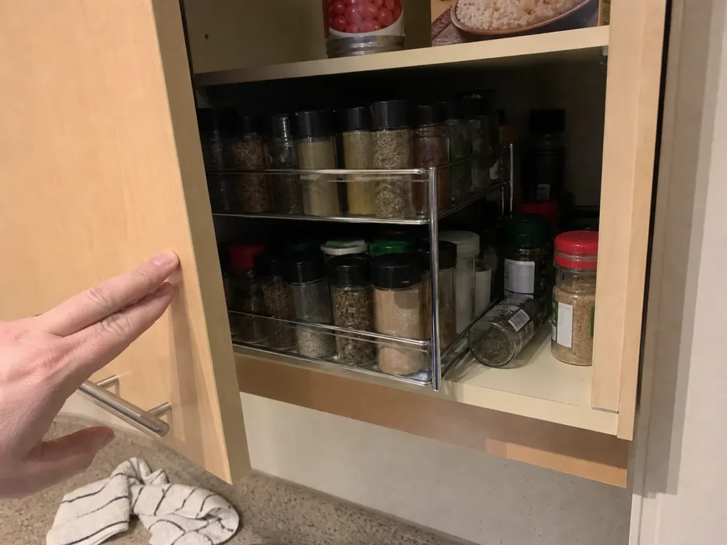 How to Organize Spices in a Small Kitchen Without a Rack 1 Tiered spice rack overhanging a shallow cabinet shelf so the cabinet door will not close
