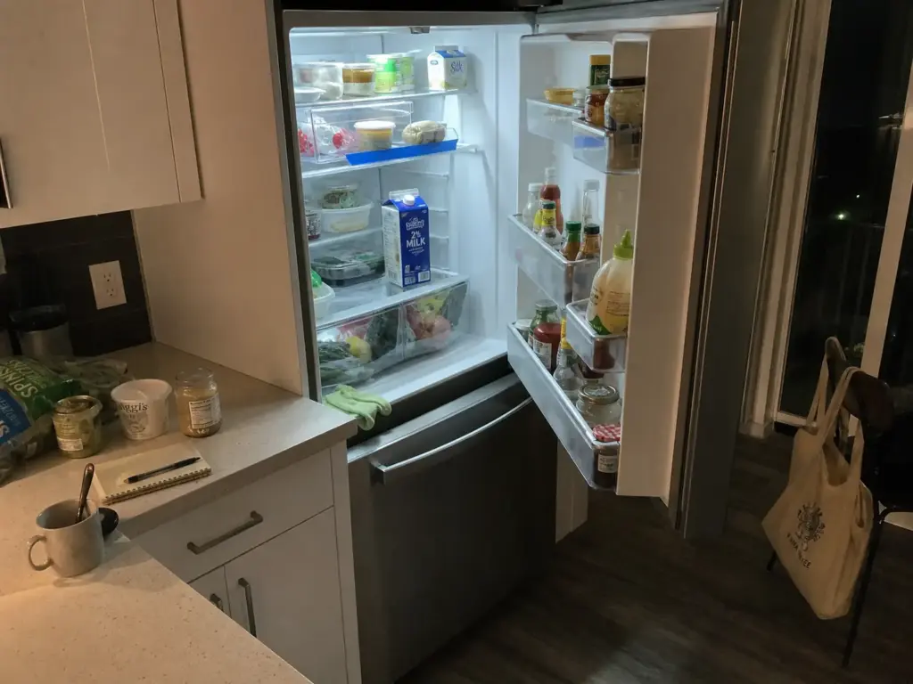 Fridge shelf during a weekly clean-out sweep with a front bin holding food to eat first