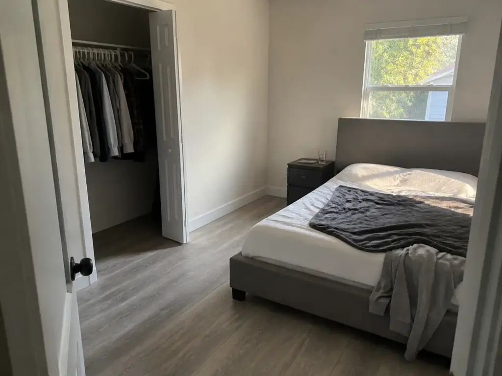 Small bedroom with the bed floated off the wall showing clear walkway space on the access side