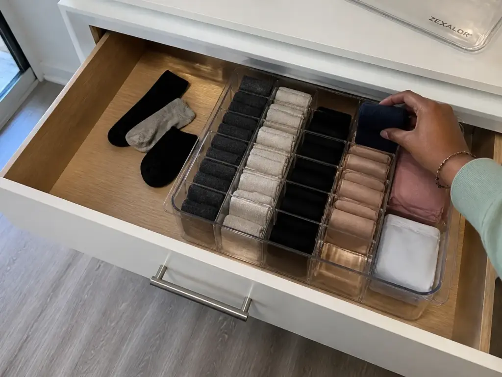 Tape measure checking the interior depth of a shallow dresser drawer with 4-inch dividers