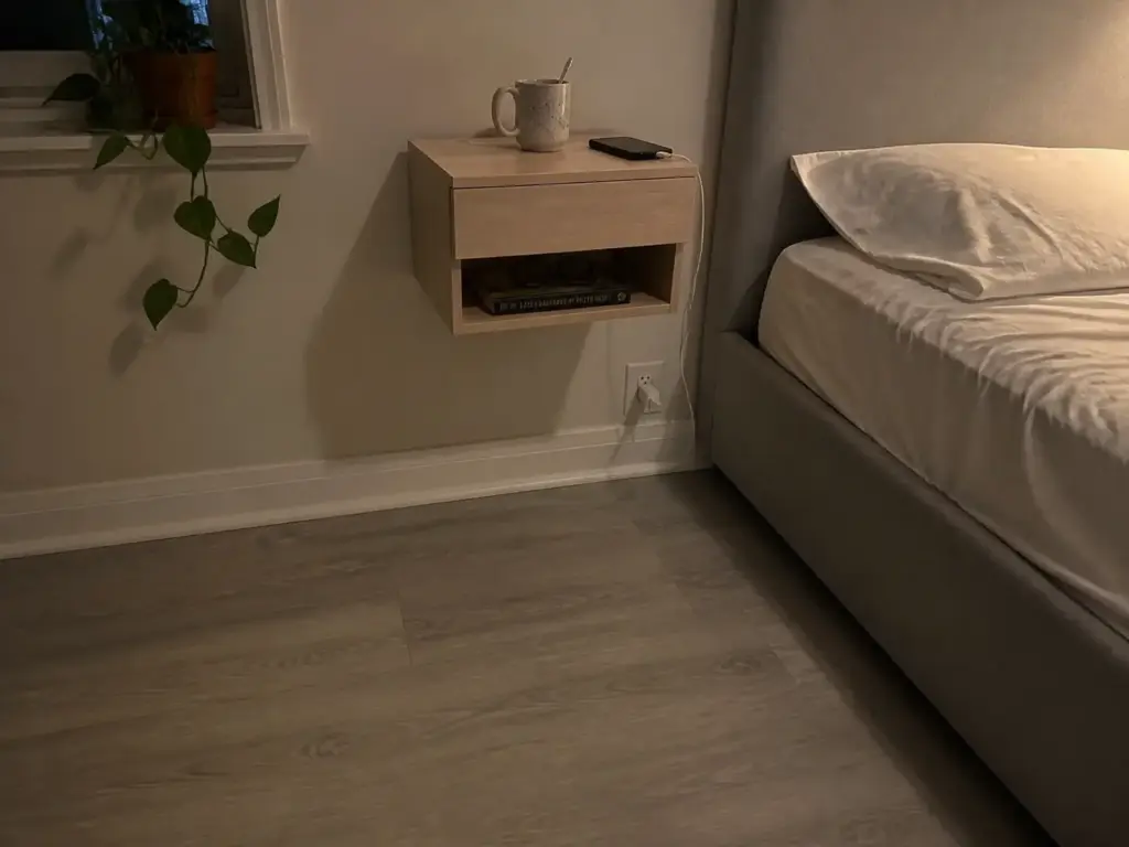 Wall-mounted floating nightstand beside a bed in a small bedroom, keeping the floor clear