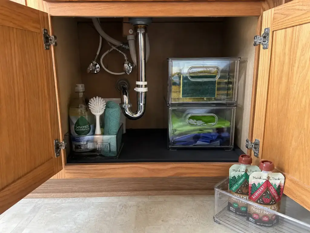 Under sink cabinet split into a daily-use front zone and stacked clear backstock bins at the back