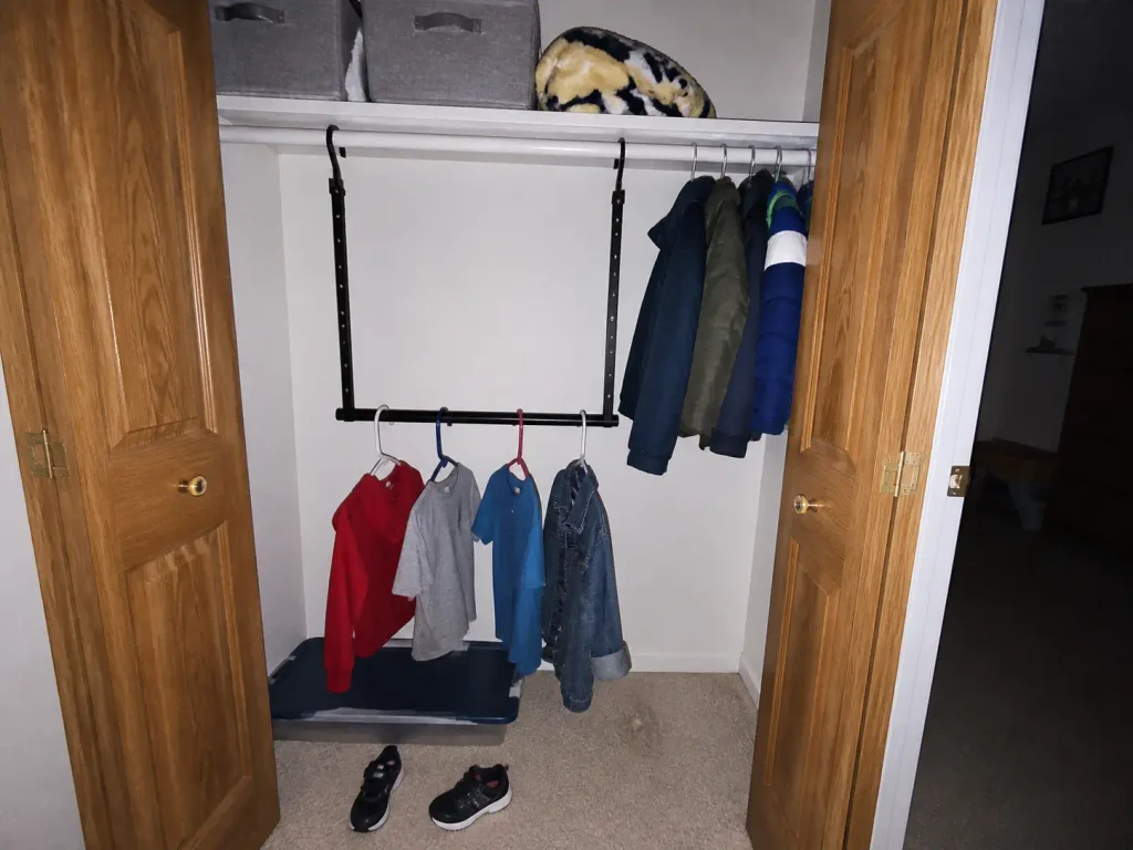 Second closet rod hung at child height under the adult rod in a kids bedroom closet