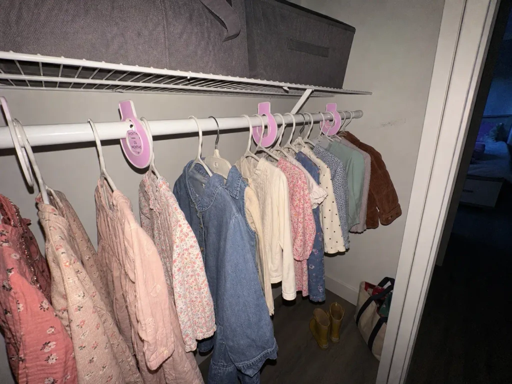 Closet rod size dividers separating kids clothes by size in a narrow rental reach-in closet