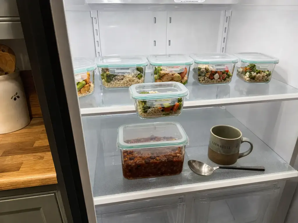 Single-serve containers at eye level above a large family-size batch on the lower fridge shelf
