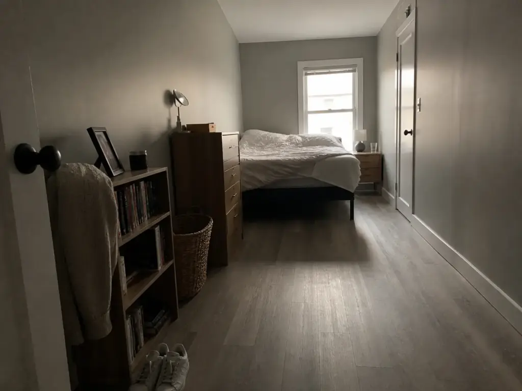 Long narrow small bedroom with the bed on the short wall keeping one clear walkway