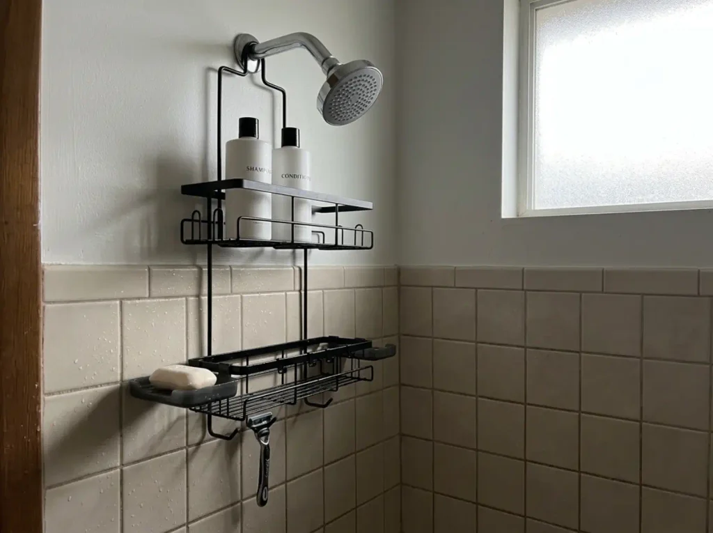 Slim hanging caddy over an exposed showerhead holding a pared-down set of bottles