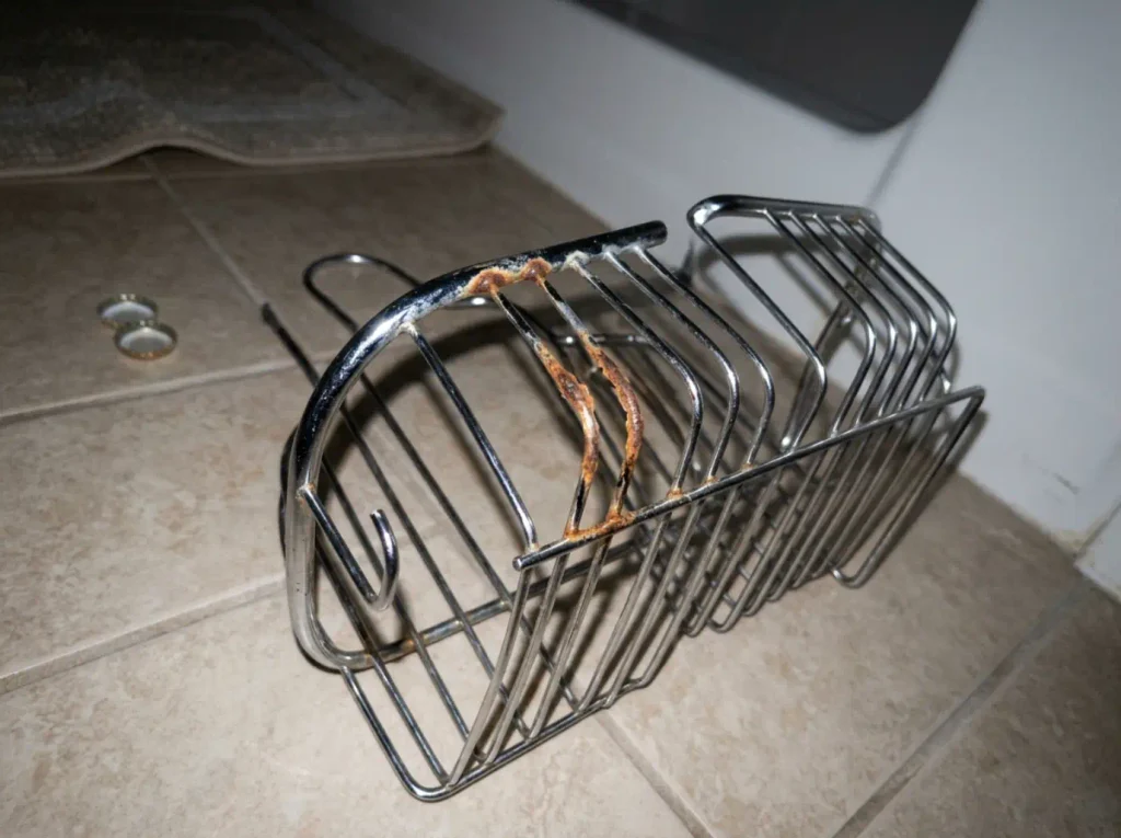 Best Shower Caddies for Renters and Shared Baths 11 Close-up of rust starting at the seam of an old chrome shower caddy next to a clean stainless one