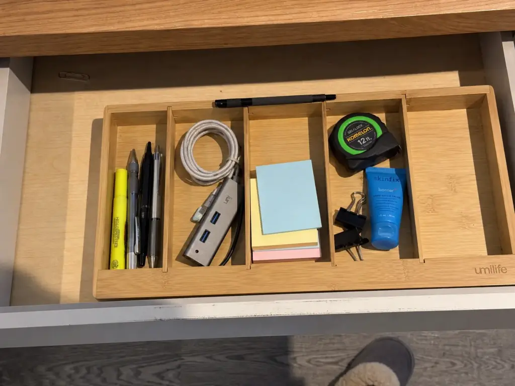 Aesthetic Desk Organization Ideas That Survive Week Two 9 Open desk drawer with a bamboo organizer and adjustable dividers sorting pens, cables and small supplies
