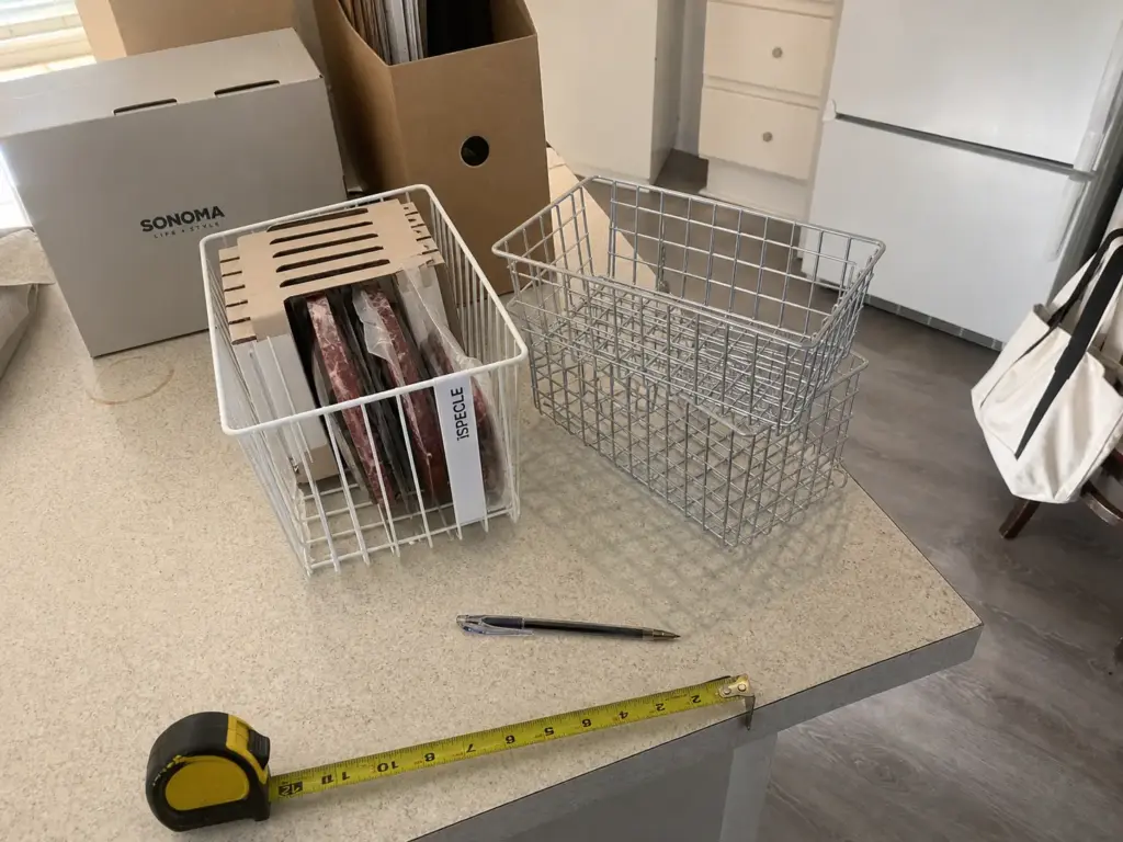 Wire freezer basket and white upright freezer bin side by side with a tape measure before buying