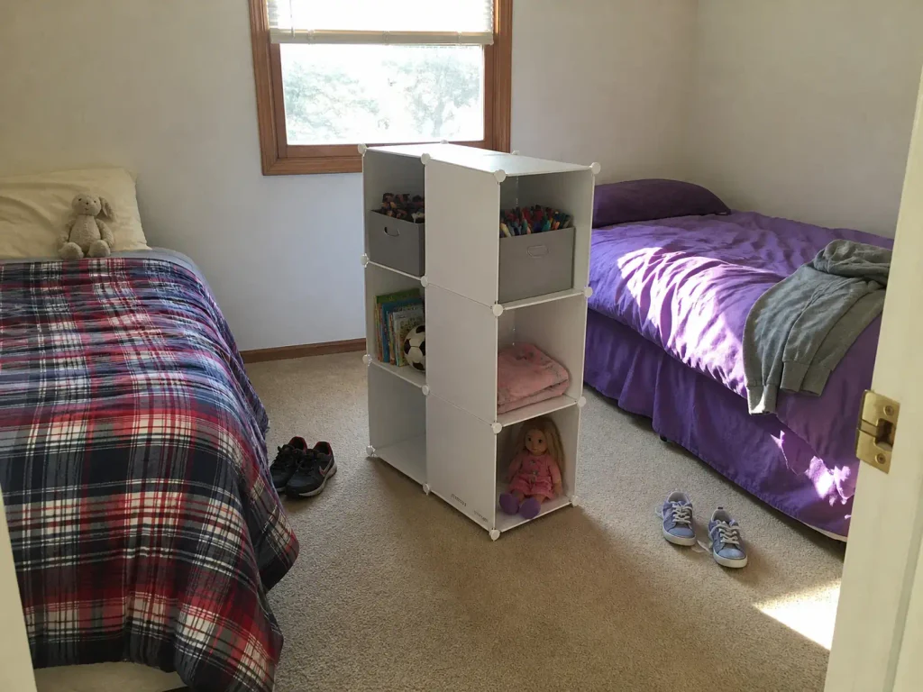 Freestanding cube organizer dividing a shared kids bedroom into two separate sides