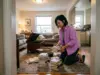 Out of Shelf Space? Organize Books in a Small Apartment Woman sorting book stacks on the living room floor of a small apartment with no bookshelf