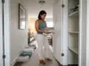 Why Your Small Linen Closet Fills Up Again in Weeks Woman sorting towel stacks in front of a narrow hallway linen closet during a small linen closet organization reset