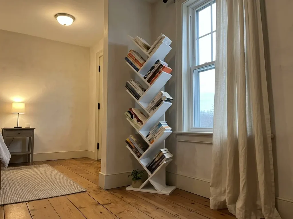 Best Bookshelves for Small Spaces That Won't Sag 6 White tree-shaped bookshelf filled with books in a narrow corner of a small living room