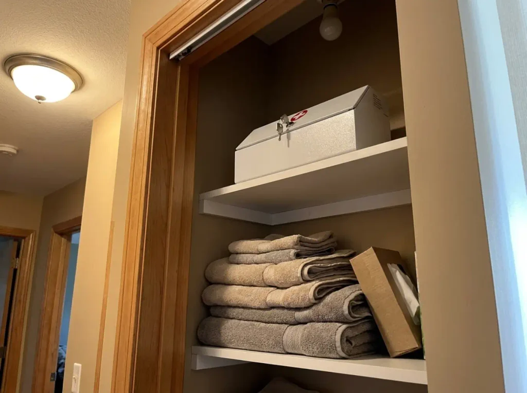 Medicine Cabinet Organization for 3-Inch Shelves 6 Small locking medicine box closed on a linen closet shelf above towels, out of a child's sight and reach